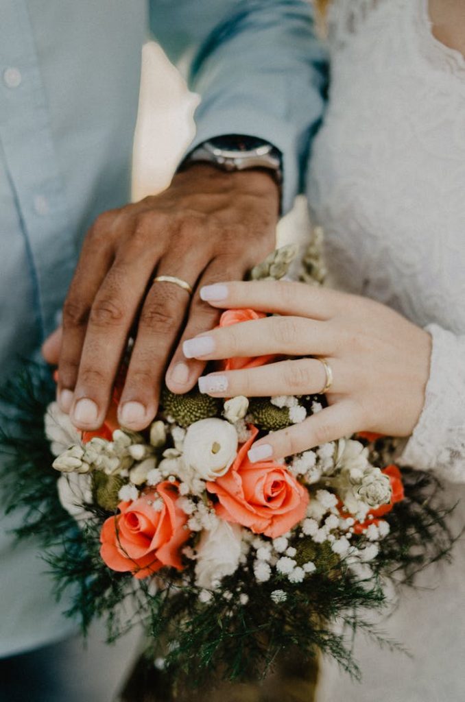 Man and Womans Hands on Top of Ball Bouquet